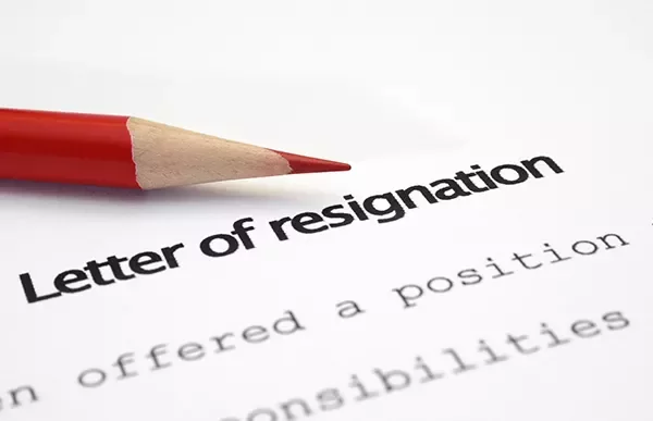 A resignation letter with a red pencil on the paper.