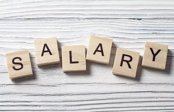 Wooden tiles spelling the word SALARY on a white textured surface.