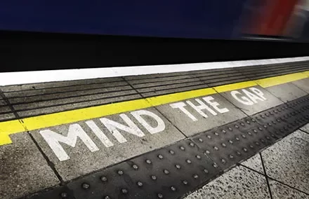 Train platform edge with 'Mind the Gap' warning.