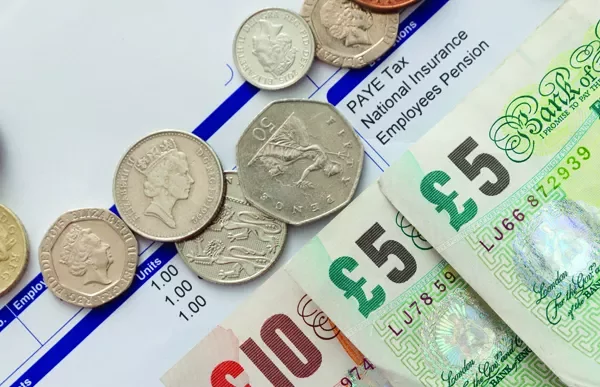 British coins and banknotes on a payslip.